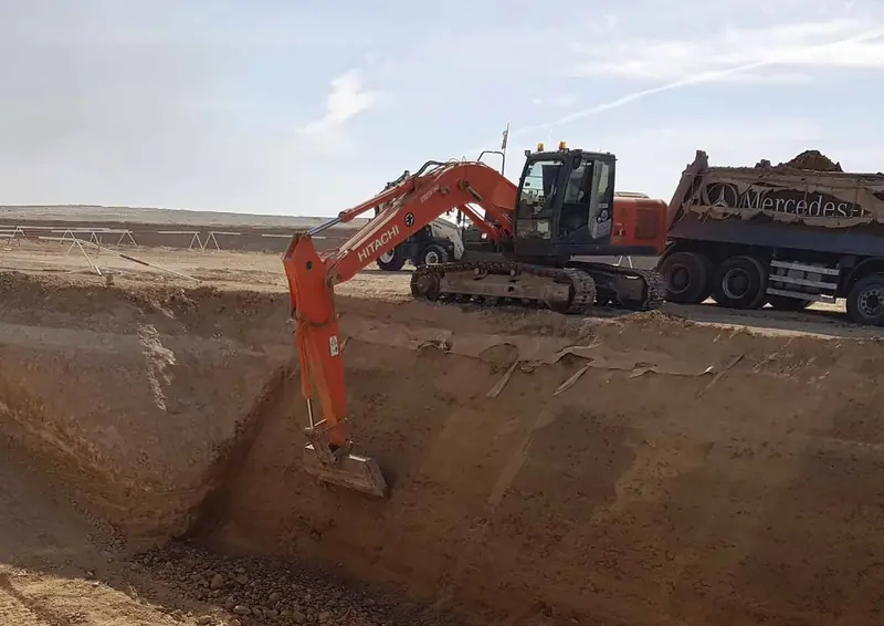 حفارة تحمّل شاحنة قلاب خلال أعمال الحفر